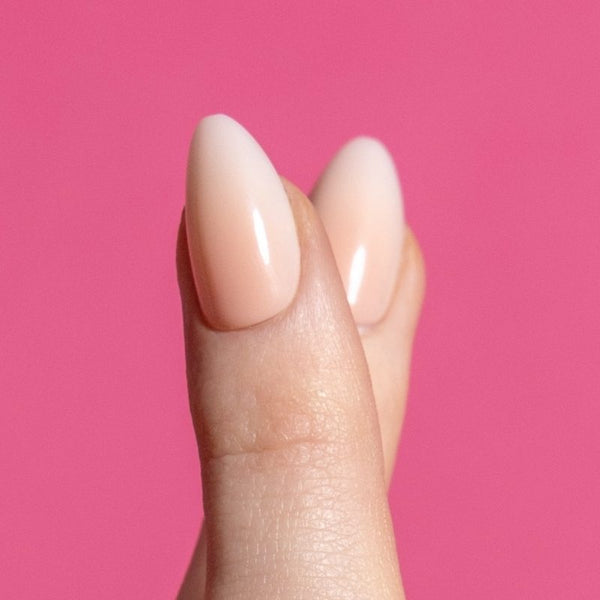 Close-up van Blush Rush ombre almond press on nagels op roze achtergrond - Freaky Nails