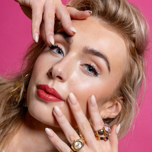 Model met Blush Rush ombre almond press on nagels en gouden sieraden - Freaky Nails