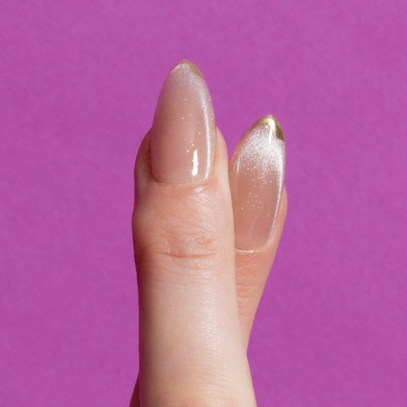 Close-up Golden Touch nude shimmer almond press on nagels met gouden tip - Freaky Nails