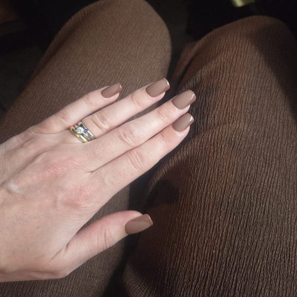 Hand met Choco Chic bruine square press on nagels op bruine outfit - Freaky Nails