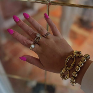 Hand met Power Punch short oval nagels en gouden sieraden - Freaky Nails