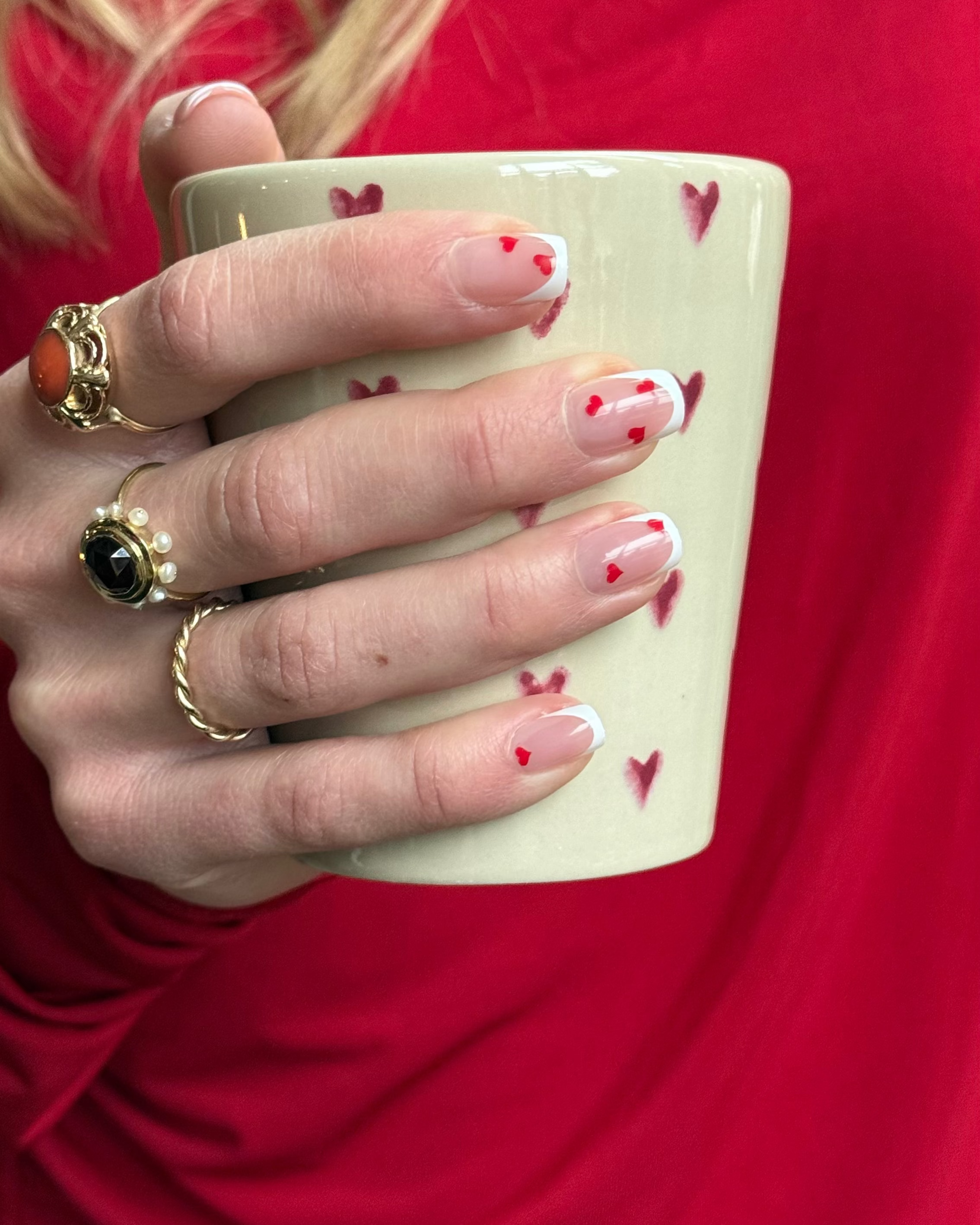 Korte plaknagels met rode hartjes en french manicure