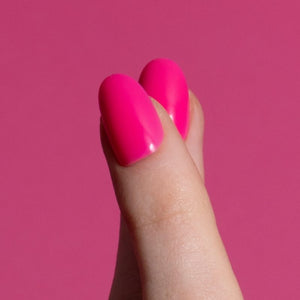 Close-up van Malibu Madness felroze short oval press on nagels op roze achtergrond - Freaky Nails