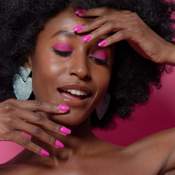 Model met Power Punch fuchsia roze nagels en turquoise oorbellen - Freaky Nails
