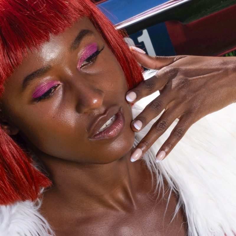 Close-up van Pastel Party shimmer french almond press on nagels op hand met donkere huid - Freaky Nails