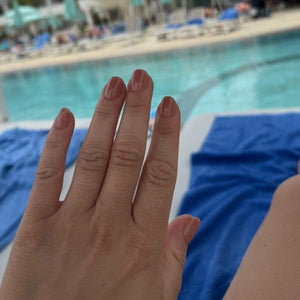 Hand met Spice Up Nude nude short square press on nagels bij het zwembad - Freaky Nails