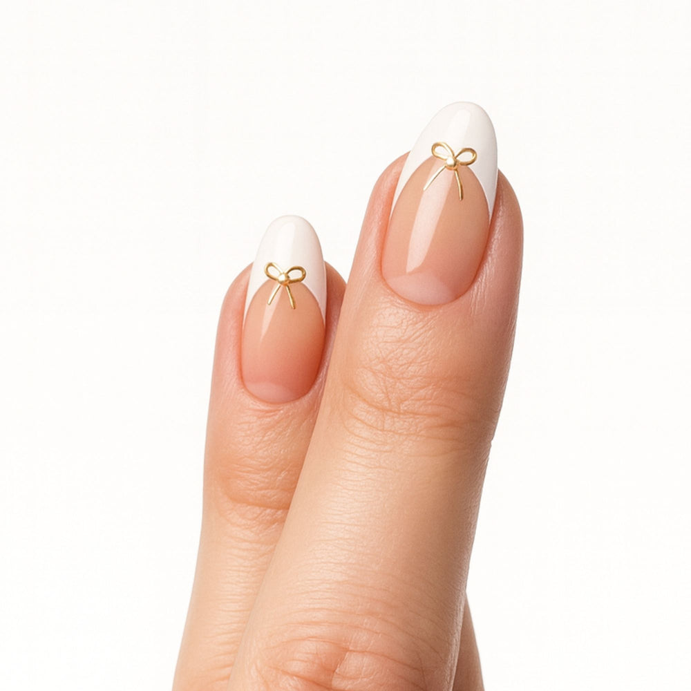 French press on nagels met gouden strik in almond vorm, Sweet & Tied van Freaky Nails.